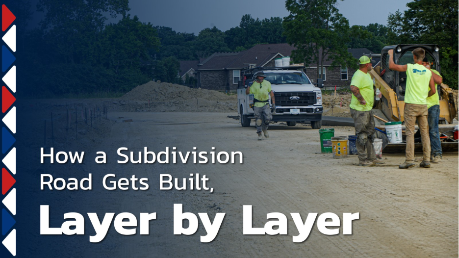 Construction crew working on a subdivision road with heavy equipment and a work truck, illustrating how a subdivision road is built layer by layer.